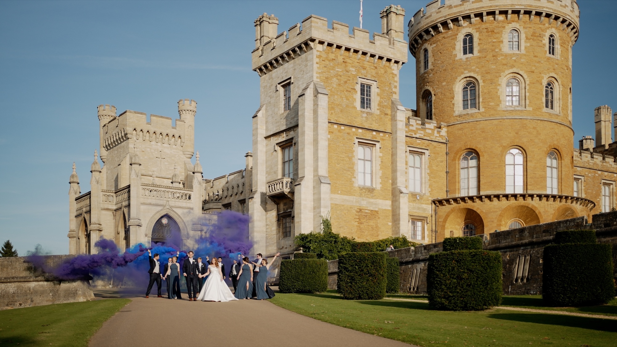 Bride, groom, bridesmaids and ushers in front of Belvoir castle