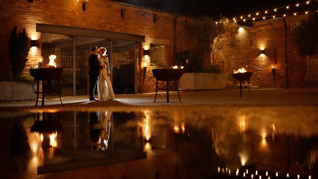 Bride and groom near fire pits at Grangefields