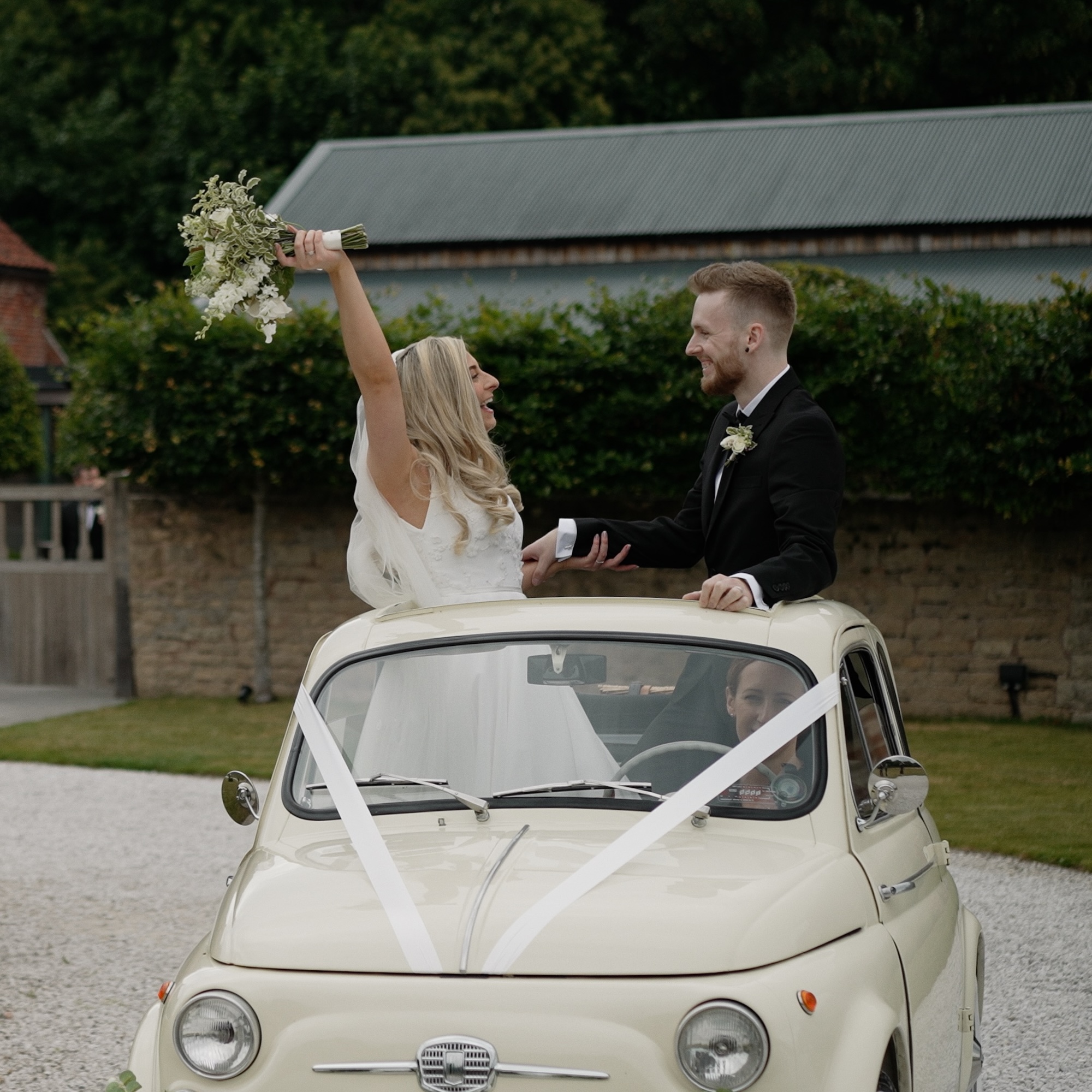 Bride and groom in a car in front of Hazel Gap Barn